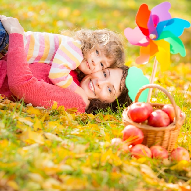 Glückliche Familie, die draußen im Herbstpark spielt