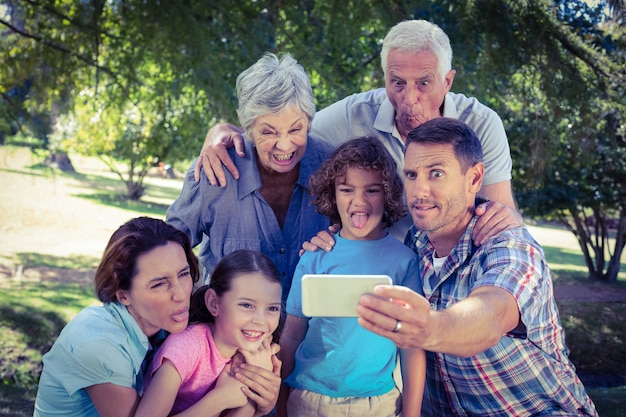 Glückliche Familie, die ein selfie im Park nimmt