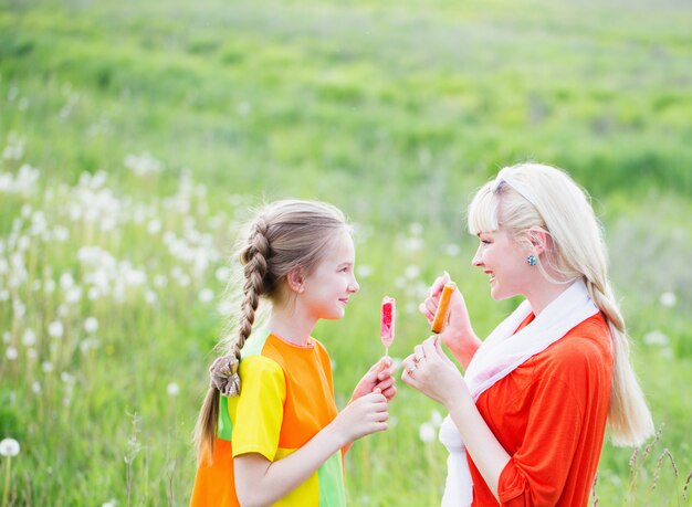 Glückliche Familie, die Eis im Freien isst