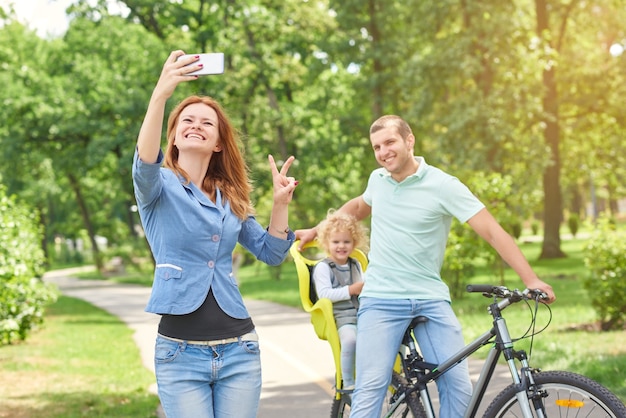 Glückliche Familie, die Fahrrad im Park fährt