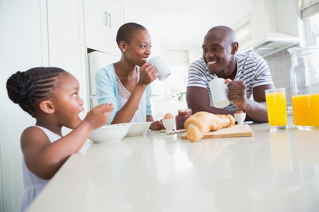 Glückliche Familie, die Frühstück sitzt und nimmt