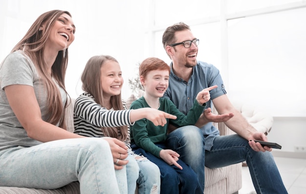Glückliche Familie, die ihr Lieblingsfernsehshowfoto mit Kopienraum anschaut