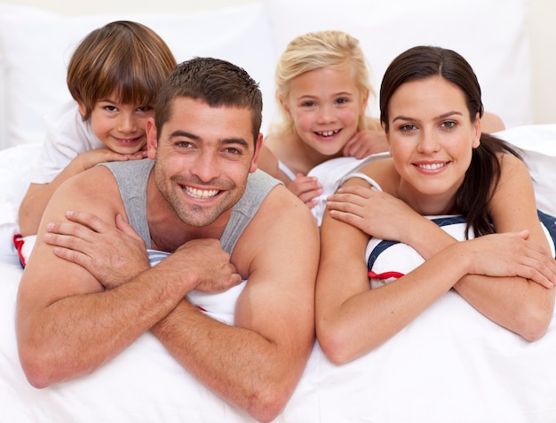 Foto glückliche familie, die im bett der eltern spielt