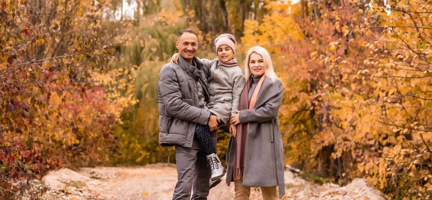 Glückliche Familie, die im Herbstpark spielt