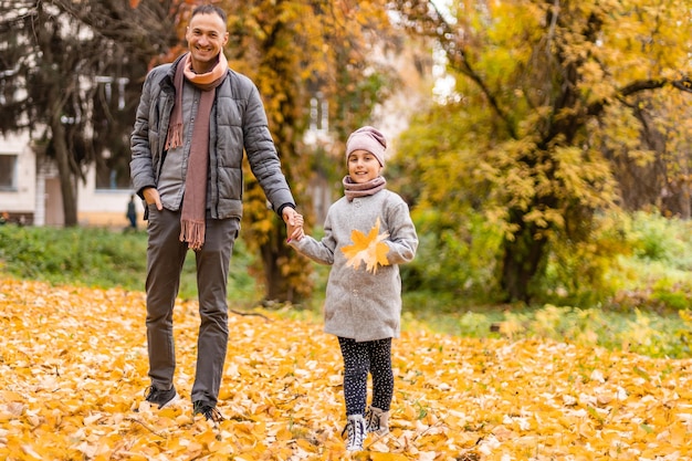 Glückliche Familie, die im Herbstpark spielt