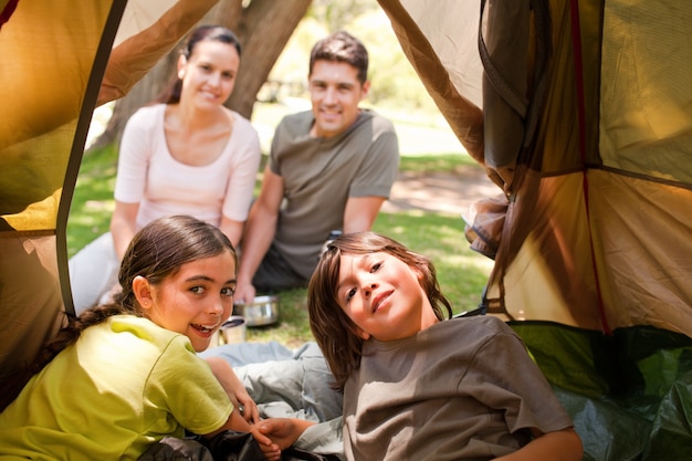 Glückliche Familie, die im Park kampiert