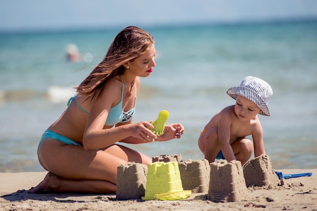 Glückliche Familie, die im Sand spielt