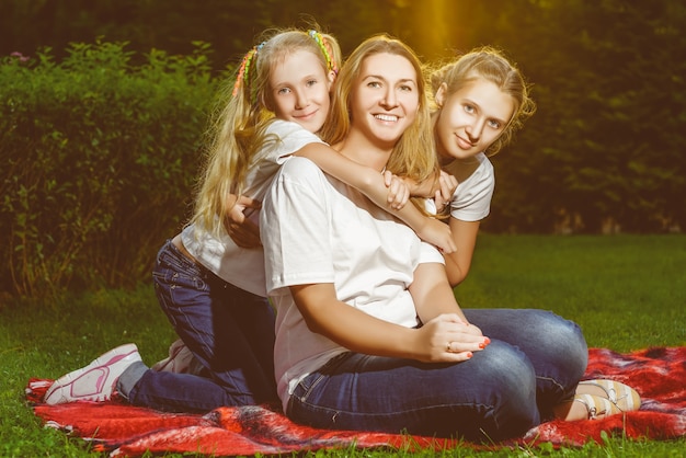 Glückliche Familie, die im Sommer auf dem Gras liegt