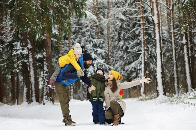 Glückliche Familie, die im Winter draußen im Schnee spielt und lacht. Wintertag im Stadtpark.