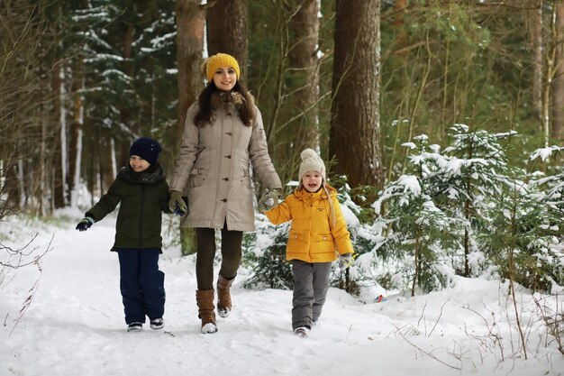 Glückliche Familie, die im Winter draußen im Schnee spielt und lacht. Wintertag im Stadtpark.