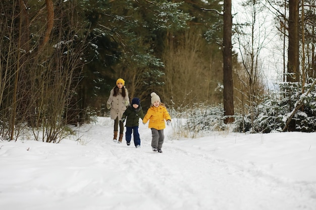 Glückliche Familie, die im Winter draußen im Schnee spielt und lacht. Wintertag im Stadtpark.