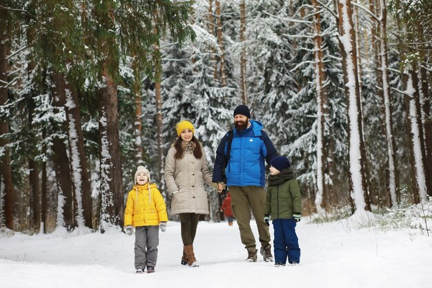 Glückliche Familie, die im Winter draußen im Schnee spielt und lacht. Wintertag im Stadtpark.