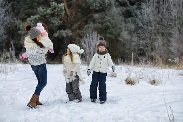 Glückliche Familie, die im Winter draußen im Schnee spielt und lacht. Wintertag im Stadtpark.