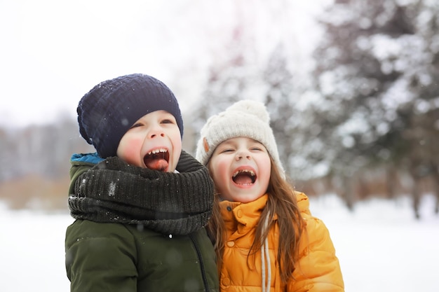 Glückliche Familie, die im Winter draußen im Schnee spielt und lacht. Wintertag im Stadtpark.