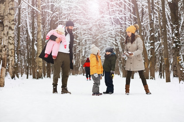 Glückliche Familie, die im Winter draußen im Schnee spielt und lacht. Wintertag im Stadtpark.