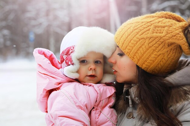 Glückliche Familie, die im Winter draußen im Schnee spielt und lacht. Wintertag im Stadtpark.