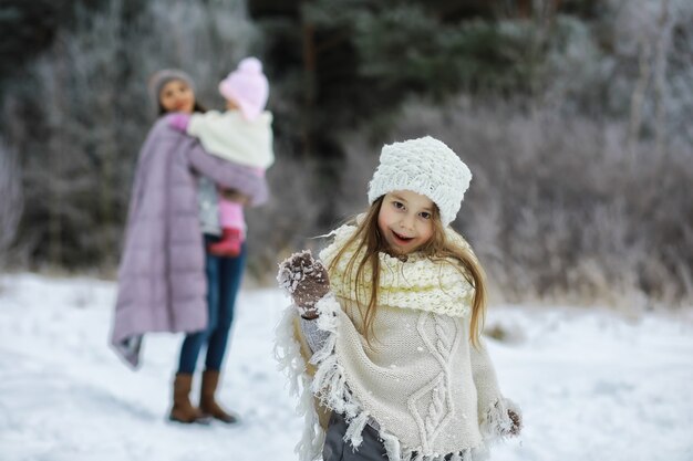 Glückliche Familie, die im Winter draußen im Schnee spielt und lacht. Wintertag im Stadtpark.