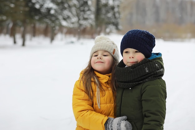 Glückliche Familie, die im Winter draußen im Schnee spielt und lacht. Wintertag im Stadtpark.