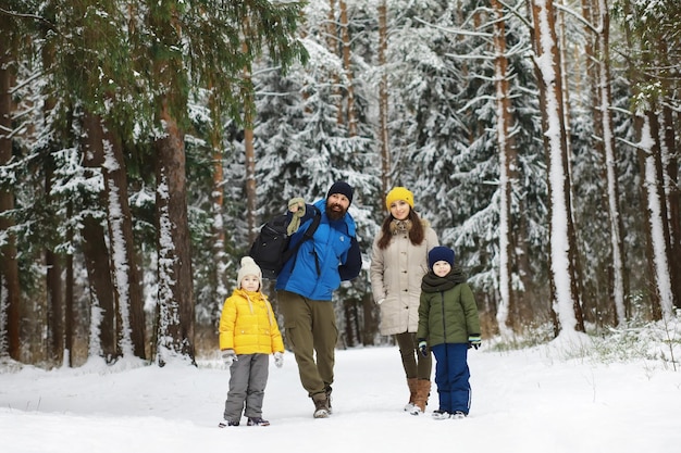 Glückliche Familie, die im Winter draußen im Schnee spielt und lacht. Wintertag im Stadtpark.