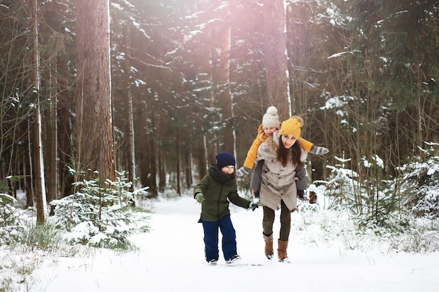 Glückliche Familie, die im Winter draußen im Schnee spielt und lacht. Wintertag im Stadtpark.