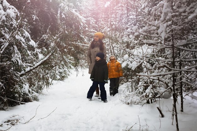 Glückliche Familie, die im Winter draußen im Schnee spielt und lacht. Wintertag im Stadtpark.