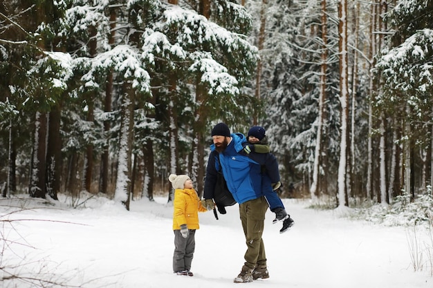 Glückliche Familie, die im Winter draußen im Schnee spielt und lacht. Wintertag im Stadtpark.