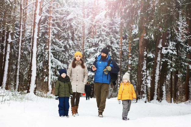 Glückliche Familie, die im Winter draußen im Schnee spielt und lacht. Wintertag im Stadtpark.