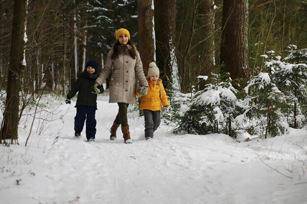 Glückliche Familie, die im Winter draußen im Schnee spielt und lacht. Wintertag im Stadtpark.