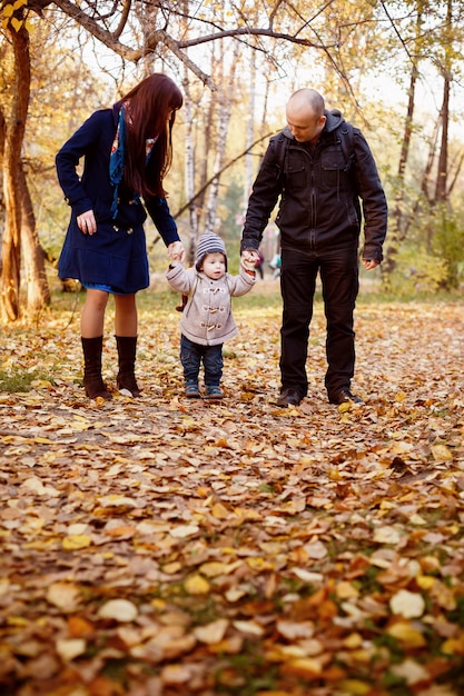 Glückliche Familie, die in Autumn Park geht