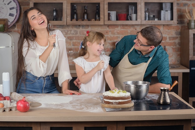 Glückliche Familie, die in der Küche singt