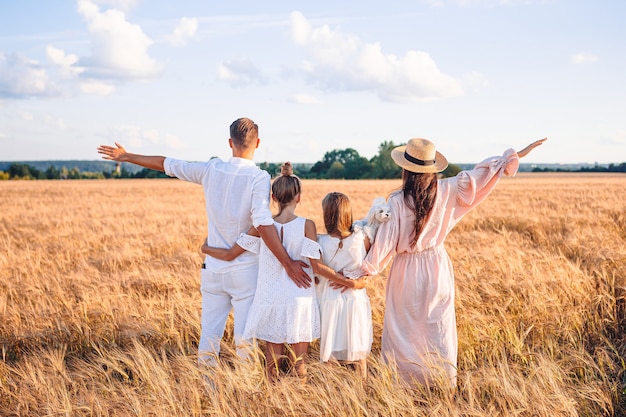 Glückliche Familie, die in einem Weizenfeld spielt