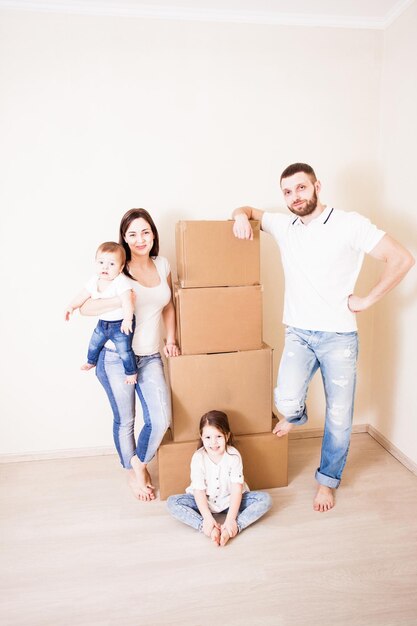 Glückliche Familie, die Kisten im Zimmer verpackt. Umzugskonzept