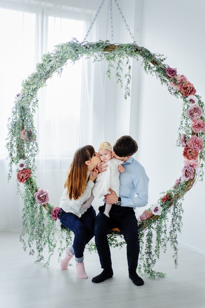 Glückliche Familie, die mit ihrem kleinen Baby sitzt. Familie verbringt Zeit zu Hause mit ihrer Tochter.