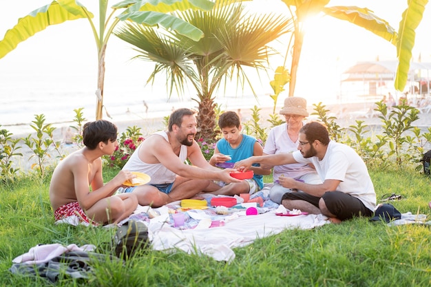 Glückliche Familie, die Picknick am Strand nahe Meer genießt?