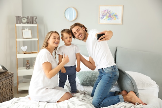 Glückliche Familie, die Selfie im Schlafzimmer macht