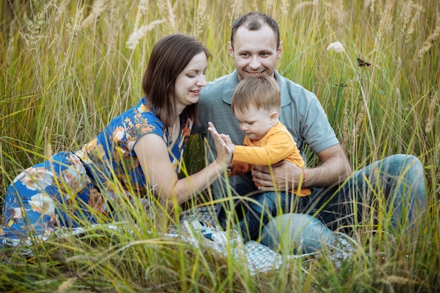 Glückliche Familie, die Spaß draußen im Gras hat