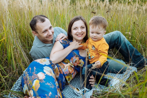 Glückliche Familie, die Spaß draußen im Gras hat