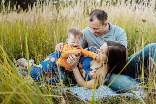 Glückliche Familie, die Spaß draußen im Gras hat