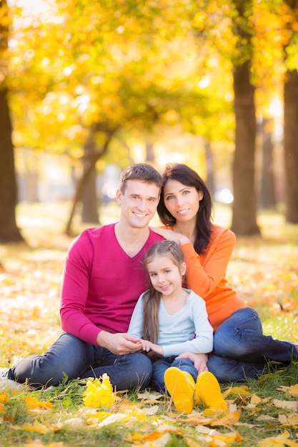 Glückliche Familie, die Spaß im Freien im Herbstpark hat