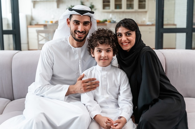 Glückliche Familie, die Zeit zusammen verbringt. Arabische Eltern und ihr Sohn spielen und machen verschiedene Aktivitäten zu Hause