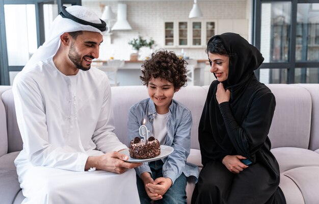 Glückliche Familie, die Zeit zusammen verbringt. Arabische Eltern und Kind feiern zusammen seinen Geburtstag