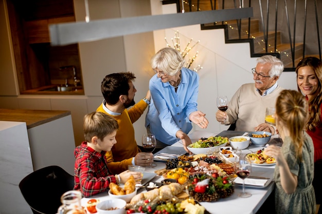 Glückliche Familie, die zu Hause mit Rotwein zu Abend isst