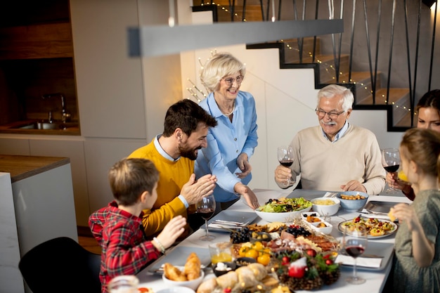 Glückliche Familie, die zu Hause mit Rotwein zu Abend isst