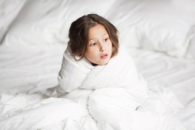 Glückliche Familie, die zu Hause unter der Decke im Bett liegt