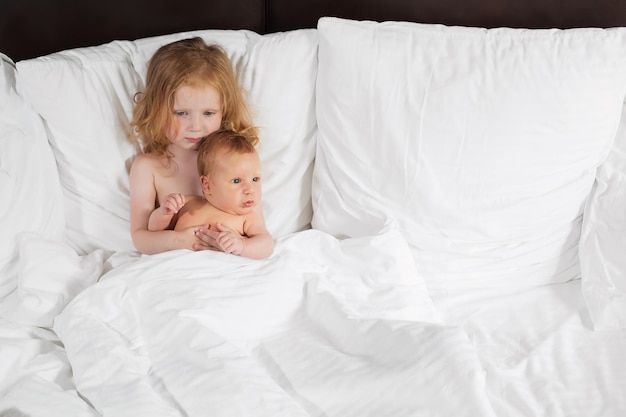 Glückliche Familie, die zu Hause unter der Decke im Bett liegt