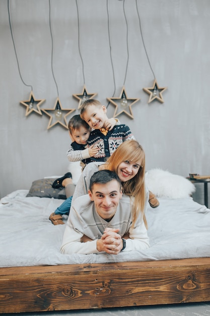 Glückliche Familie, die zusammen auf einem Bett im Schlafzimmer liegt