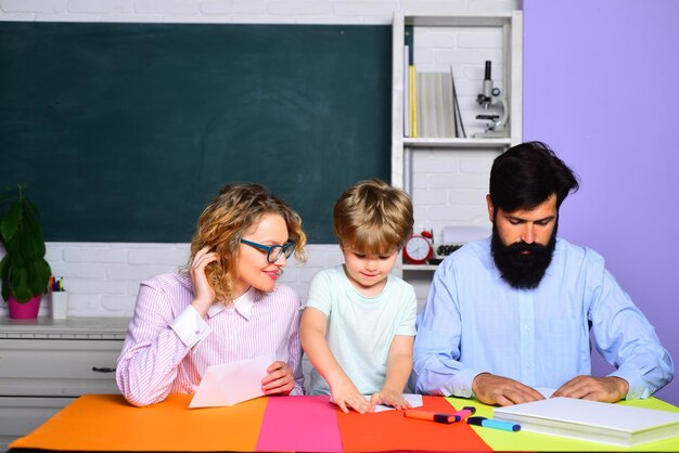 Glückliche Familie, die zusammen Mathe zum ersten Mal zur Schule bringt, hilft Kind, Junge, glückliche Familie