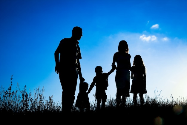 Glückliche Familie draußen in der Parkschattenbild