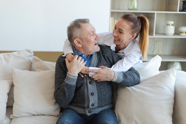 Glückliche Familie fürsorgliche erwachsene Tochter umarmt liebevollen älteren Mann Vater junge Frau umarmt Papa Oma