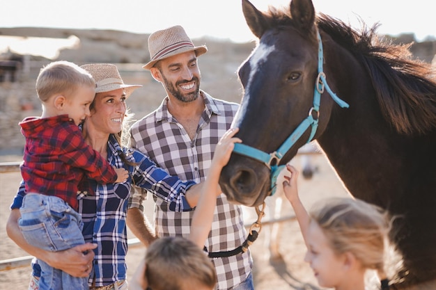 Glückliche Familie genießt den Tag auf der Pferderanch im Freien